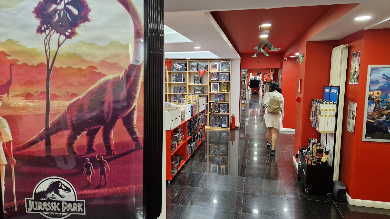 Jurassic Park mural beside shelves of comics, posters and merchandise