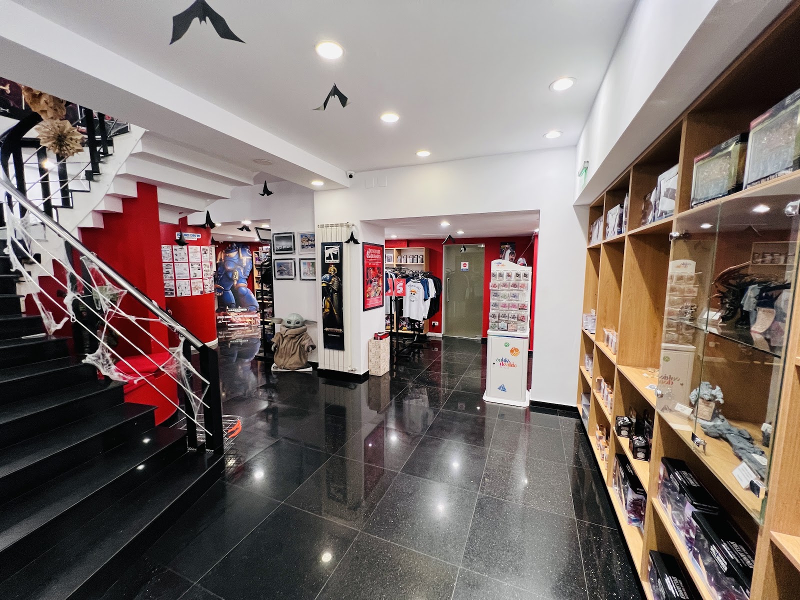Lower floor with a black staircase, Warhammer figures and apparel racks