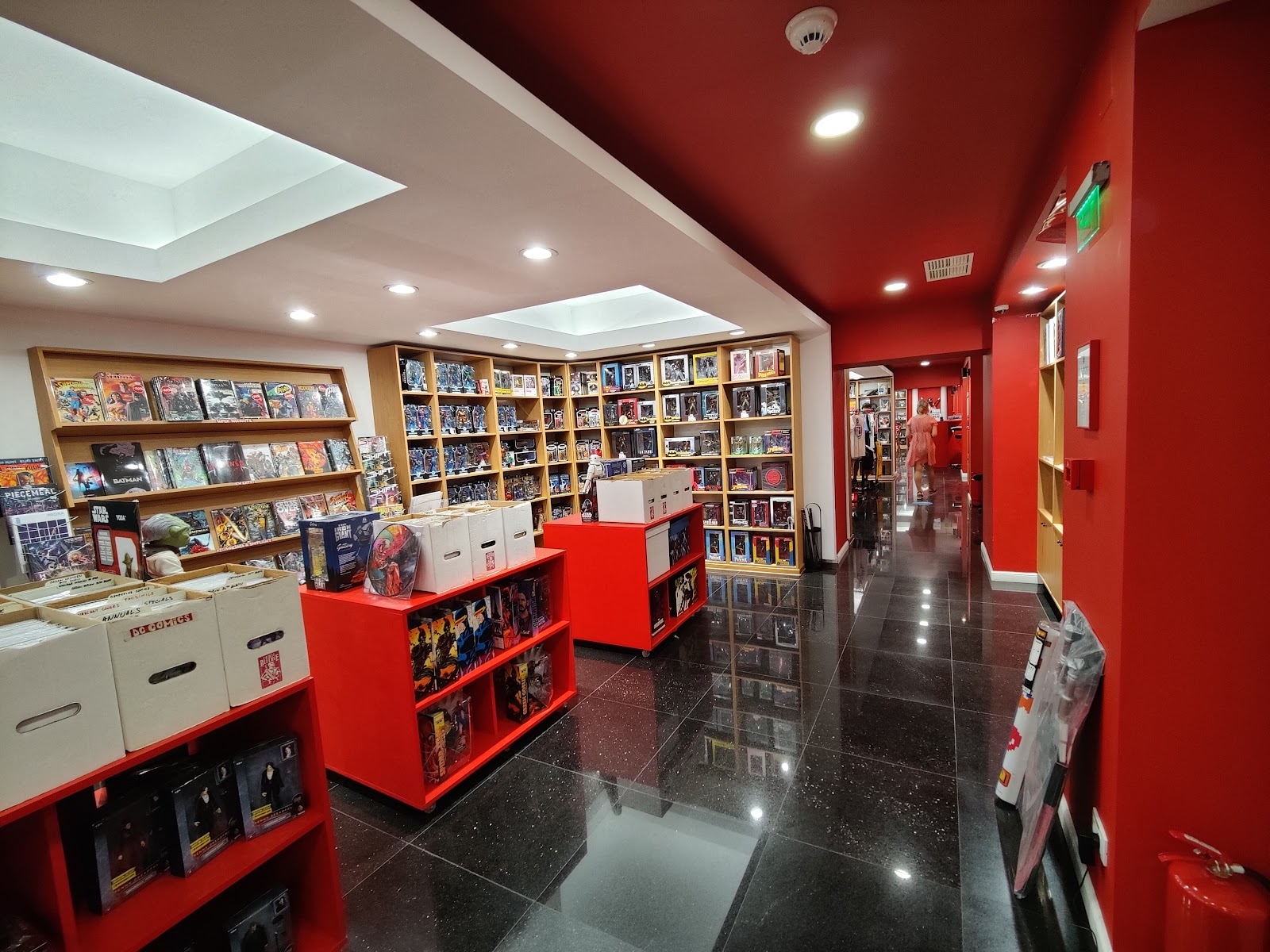 Comics and collectibles section with red display units and full shelves